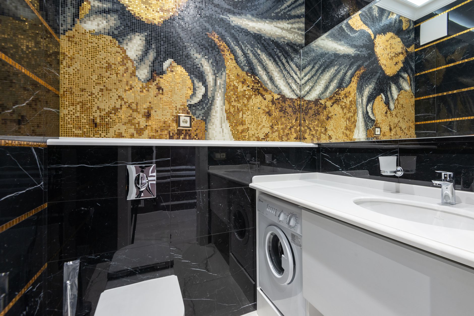 Elegant modern bathroom featuring a striking mosaic wall design with a white sink and washing machine.