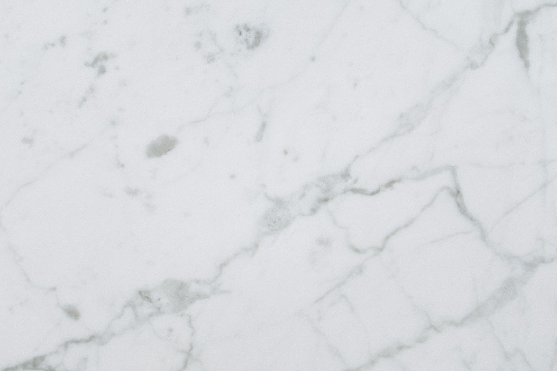 High-quality white marble surface with natural patterns for background or texture use.